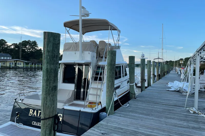 Slide: The Image of 2021 Sabre 42 Fly Bridge yacht docked at a scenic marina. - 6