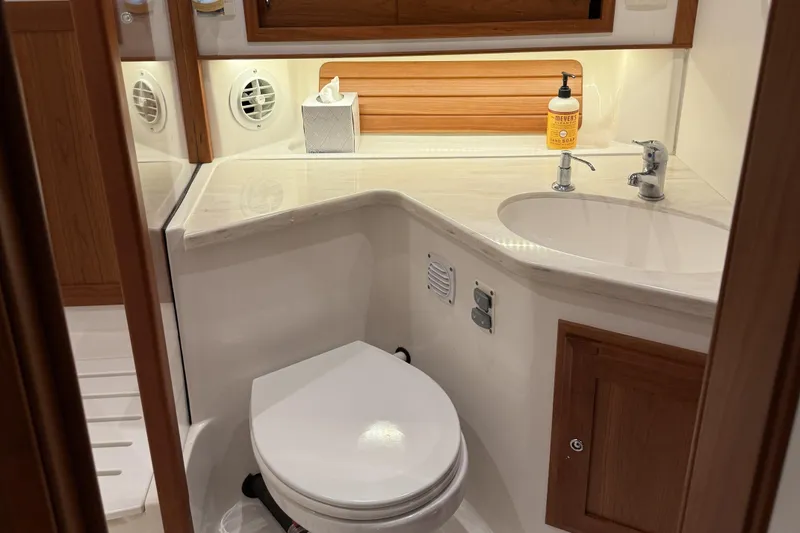 Slide: The Image of 2021 Sabre 42 Fly Bridge yacht bathroom with modern fixtures and wooden accents. - 60