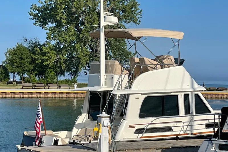 Slide: The Image of 2021 Sabre 42 Fly Bridge yacht docked by a scenic waterfront. - 7