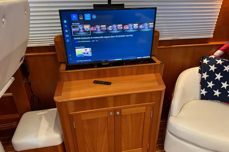 Slide: The Image of Interior of 2021 Sabre 42 Fly Bridge with TV, remote, and American flag blanket. - 71