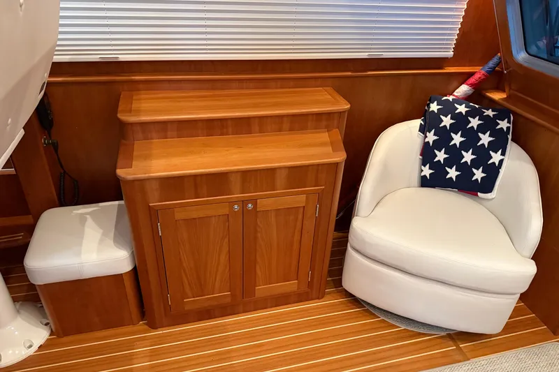 Slide: The Image of Interior of 2021 Sabre 42 Fly Bridge with wooden cabinetry and white seating. - 72