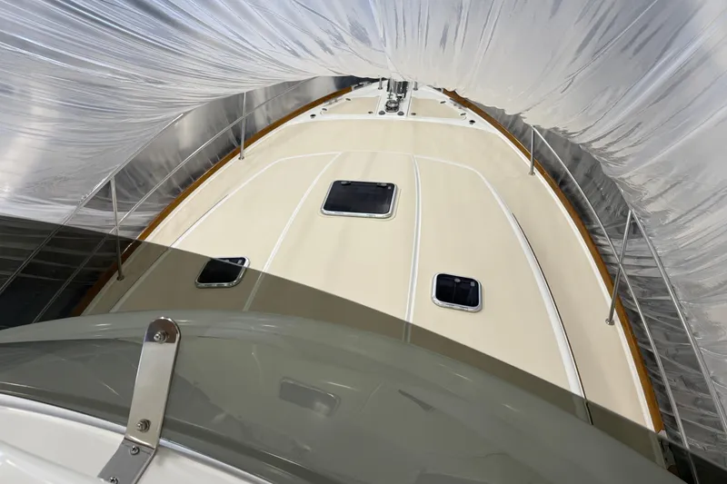 Slide: The Image of 2021 Sabre 42 Fly Bridge yacht under protective cover, showcasing deck and hatches. - 9