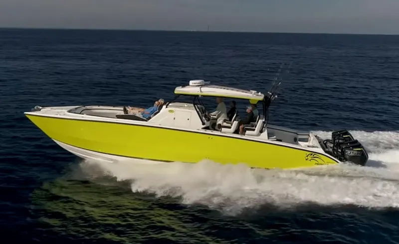 The Image of 2020 Prowler 42 boat cruising on open water, vibrant yellow hull, multiple passengers onboard. - 1