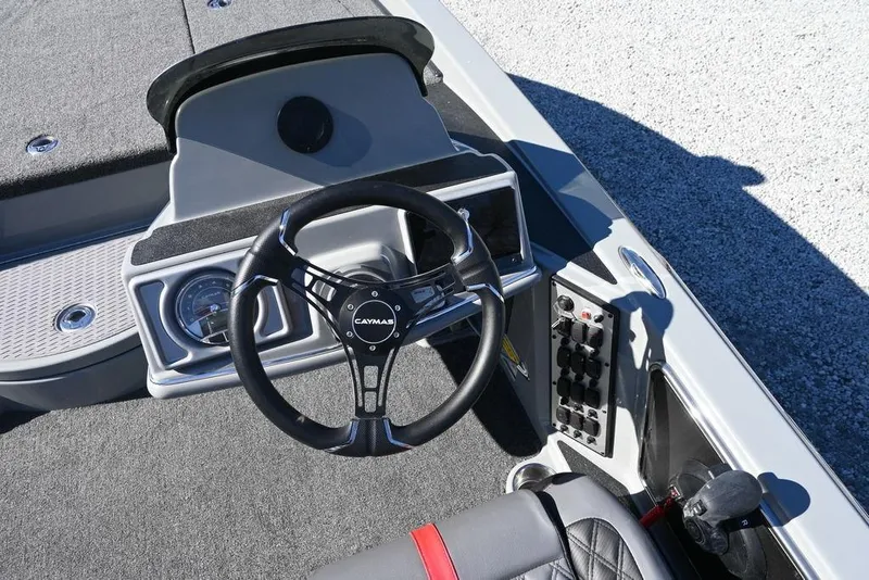Slide: The Image of 2025 Caymas 201 Pro boat dashboard with steering wheel and control panel. - 10