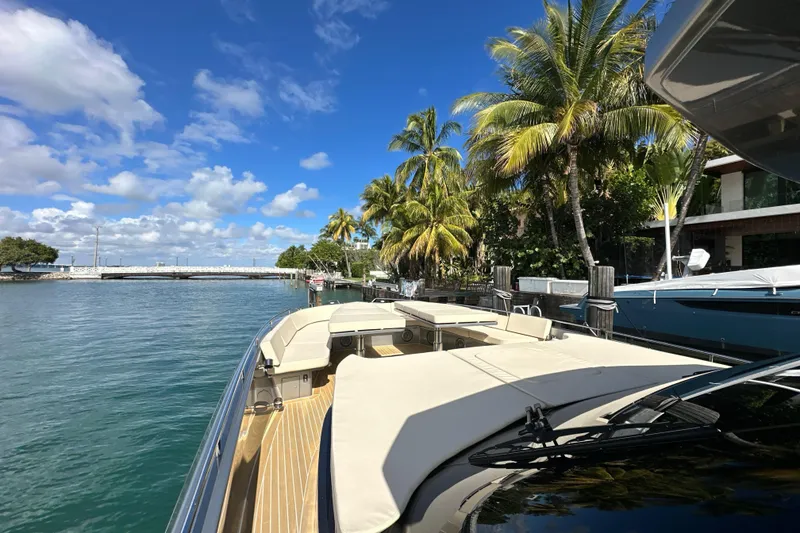 Slide: The Image of Luxurious CNM 54 yacht docked by palm trees, clear blue sky, and calm waters. - 10