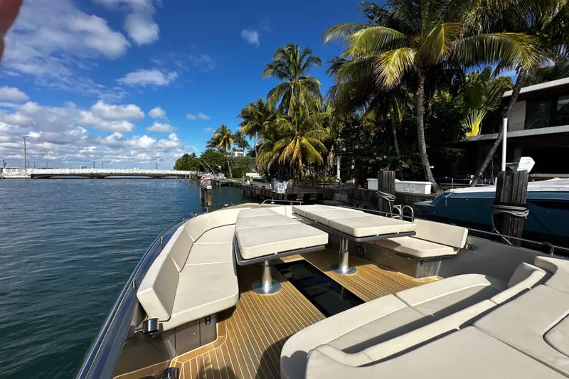 Slide: The Image of Luxurious CNM 54 yacht from 2019 docked by palm trees under a clear blue sky. - 13