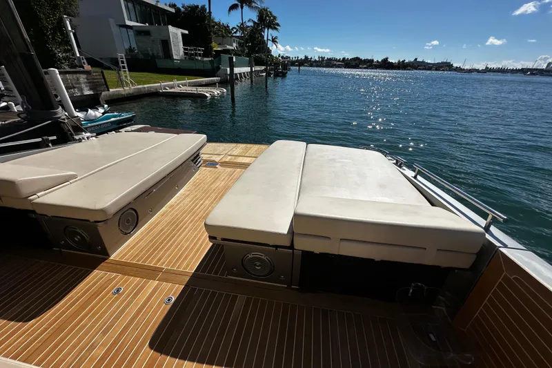 Slide: The Image of Luxurious CNM 54 yacht deck with sun loungers, overlooking serene waterfront, 2019 model. - 17