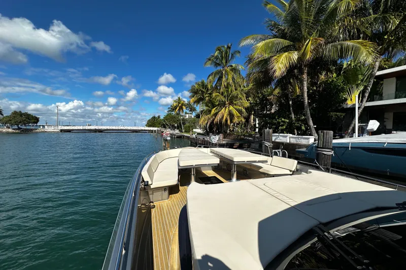 The Image of Luxury CNM 54 yacht docked by palm trees, clear blue sky, and calm water. - 2