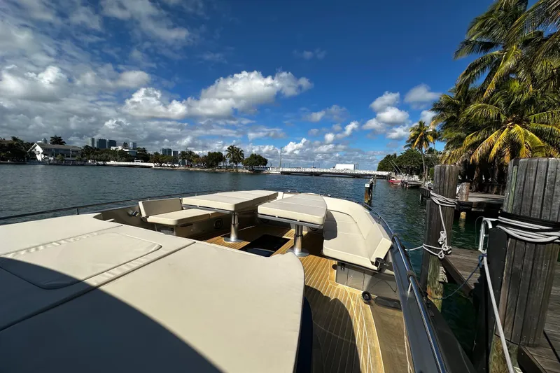 Slide: The Image of Luxurious 2019 CNM 54 yacht docked by palm trees under a vibrant blue sky. - 20