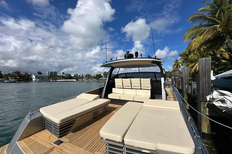 Slide: The Image of Luxurious 2019 CNM 54 yacht docked, featuring spacious sunbeds and elegant design under a clear blue sky. - 24