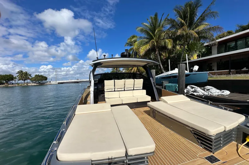 Slide: The Image of Luxurious 2019 CNM 54 yacht docked by palm trees under a clear blue sky. - 25