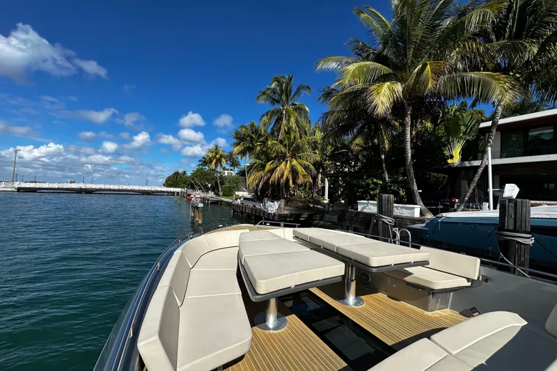 Slide: The Image of Luxurious CNM 54 yacht docked by palm trees, clear blue sky, and calm waters. - 37