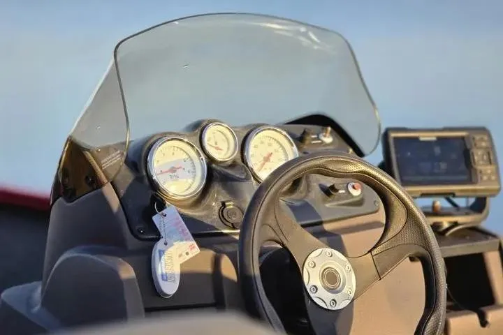 Slide: The Image of 2021 Tracker Super Guide V-16 SC boat dashboard with steering wheel and gauges. - 17
