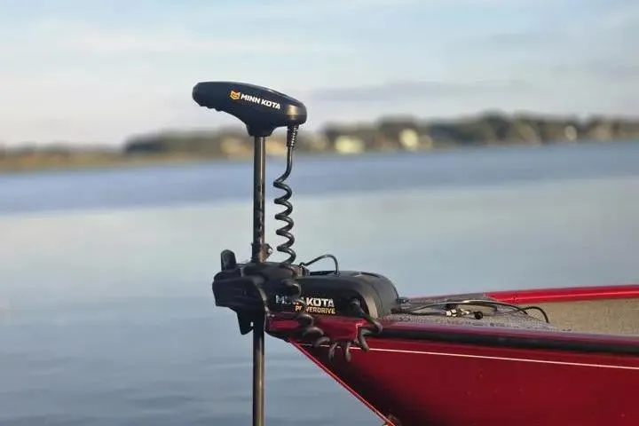 Slide: The Image of 2021 Tracker Super Guide V-16 SC boat with Minn Kota trolling motor on a calm lake. - 4