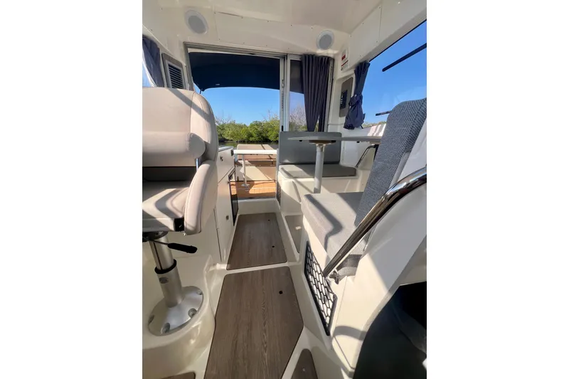 Slide: The Image of 2024 Bayliner Trophy T25 Explorer interior with seating and table, showcasing modern design. - 11