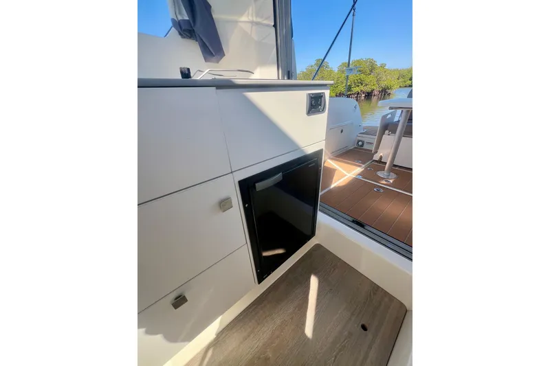 Slide: The Image of 2024 Bayliner Trophy T25 Explorer interior with cabinetry and outdoor view. - 13