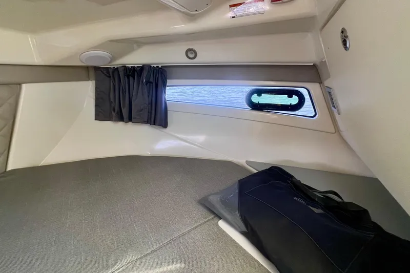Slide: The Image of 2024 Bayliner Trophy T25 Explorer cabin interior with window and storage bag. - 17