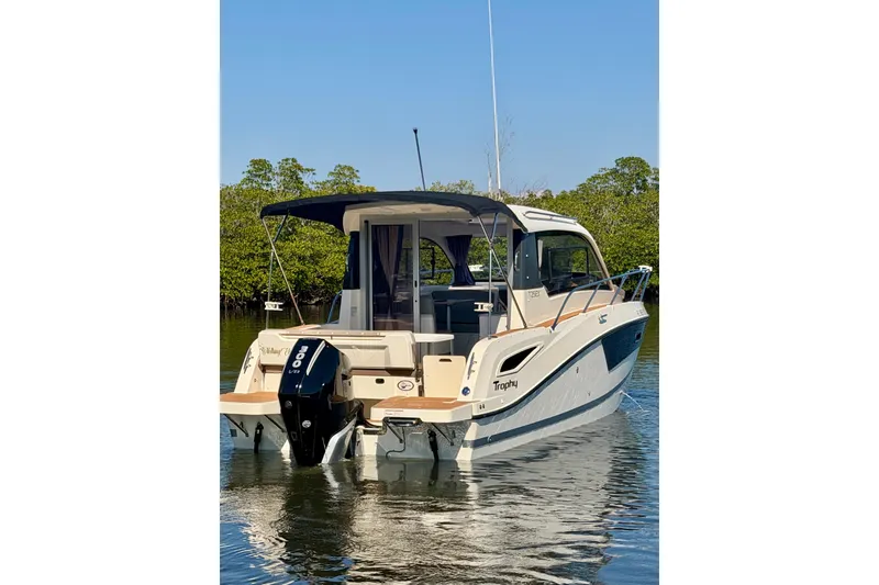 Slide: The Image of 2024 Bayliner Trophy T25 Explorer boat on calm water, rear view. - 2