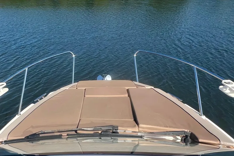 Slide: The Image of 2024 Bayliner Trophy T25 Explorer boat bow with cushioned seating on calm water. - 20