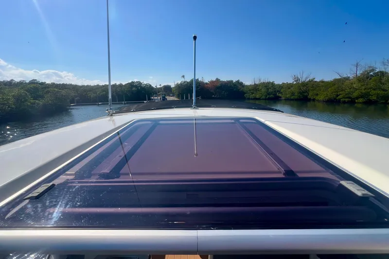 Slide: The Image of 2024 Bayliner Trophy T25 Explorer cruising on a sunny day, surrounded by lush greenery. - 22