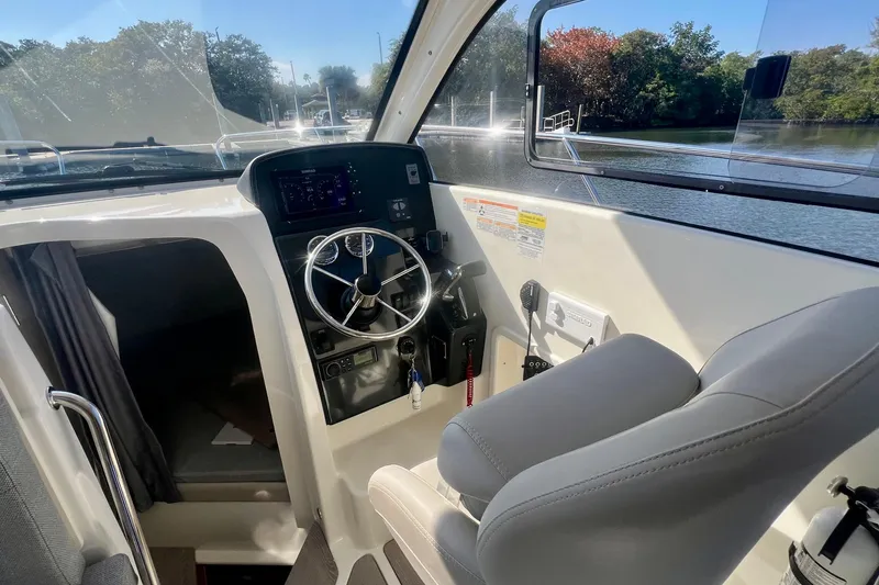 Slide: The Image of 2024 Bayliner Trophy T25 Explorer helm with steering wheel and navigation controls. - 4