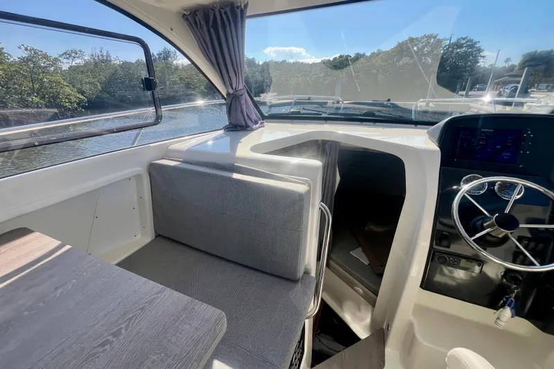 Slide: The Image of Interior of 2024 Bayliner Trophy T25 Explorer boat with modern seating and steering area. - 5