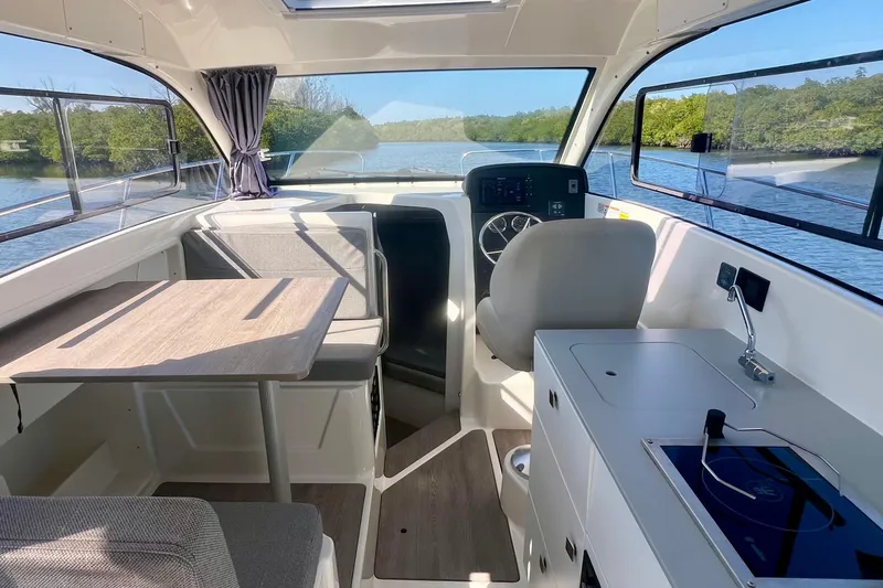 Slide: The Image of Interior of 2024 Bayliner Trophy T25 Explorer boat with seating, table, and helm. - 8