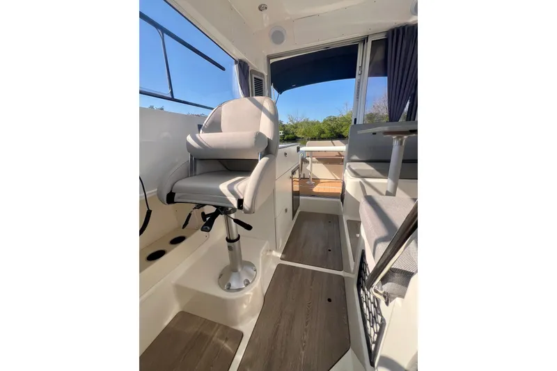 Slide: The Image of 2024 Bayliner Trophy T25 Explorer interior with helm seat and cabin view. - 9
