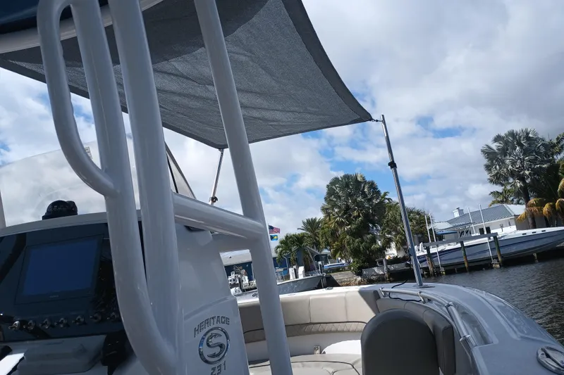 Slide: The Image of 2023 Sportsman Heritage 231 Center Console boat docked by palm trees under cloudy sky. - 34