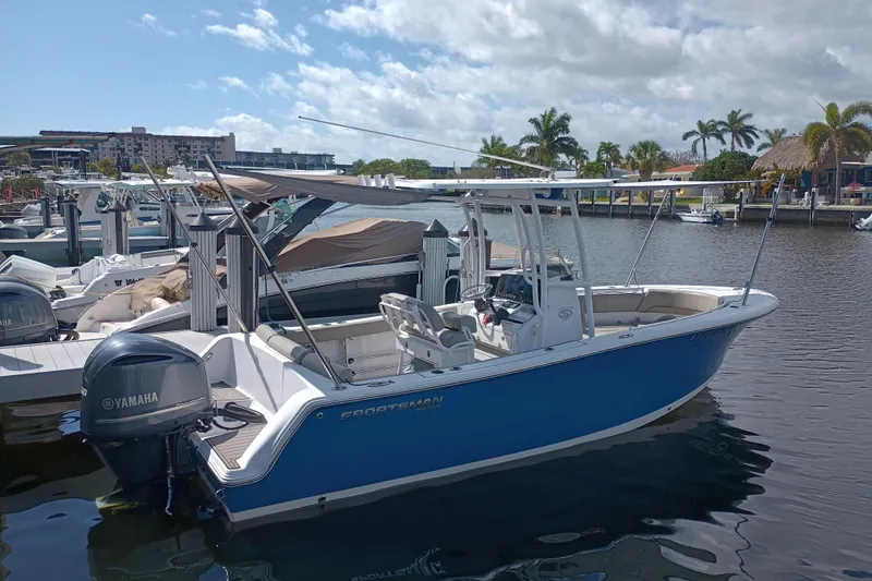 Slide: The Image of 2023 Sportsman Heritage 231 Center Console boat docked, featuring Yamaha engine, under sunny skies. - 38
