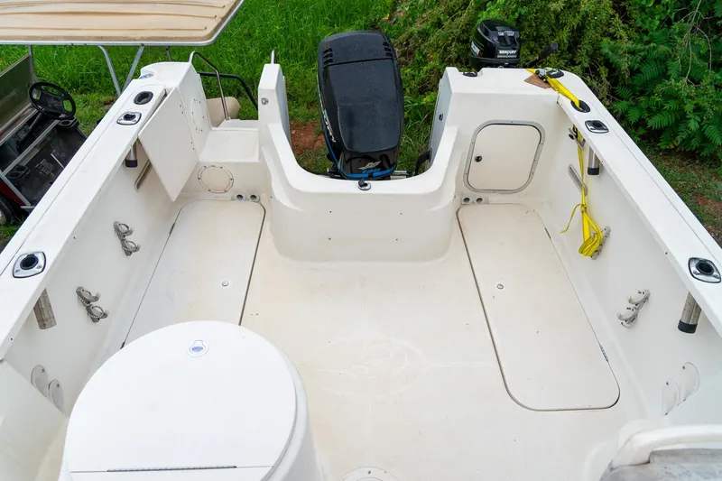Slide: The Image of 2002 Bayliner 2302 Trophy Walkaround boat interior with motor and fishing equipment. - 13