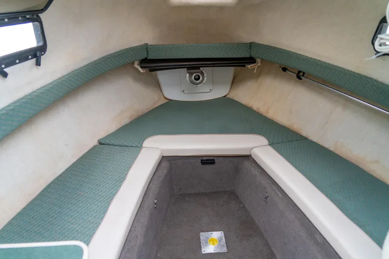 Slide: The Image of 2002 Bayliner 2302 Trophy Walkaround cabin interior with green cushions and compact layout. - 22