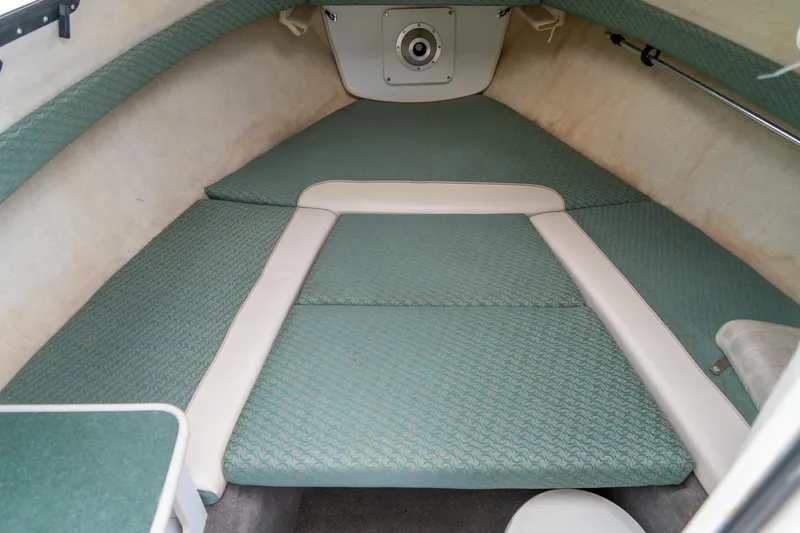 Slide: The Image of 2002 Bayliner 2302 Trophy Walkaround cabin interior with green cushioned seating. - 23