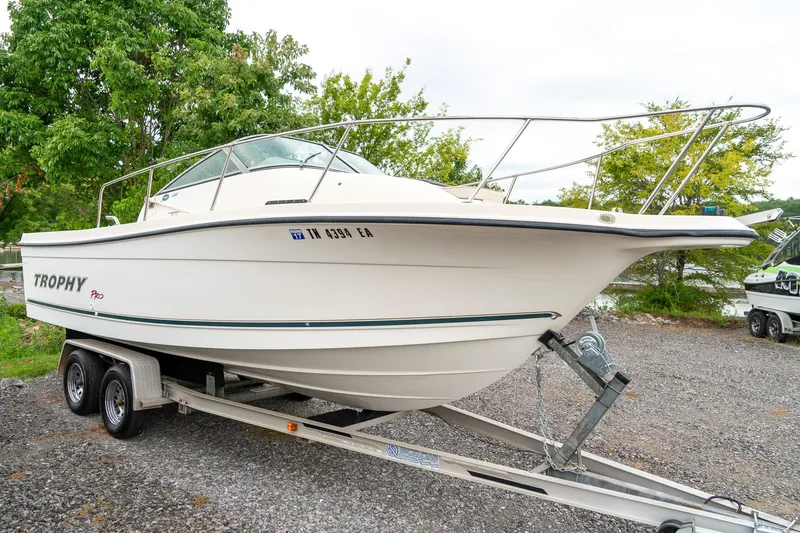Slide: The Image of 2002 Bayliner 2302 Trophy Walkaround boat on trailer, parked outdoors. - 4