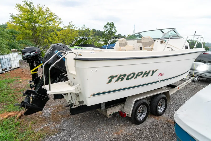 Slide: The Image of 2002 Bayliner 2302 Trophy Walkaround boat on trailer, featuring Mercury outboard motor. - 5