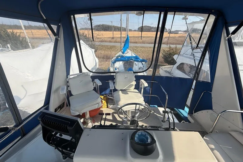 Slide: The Image of 1990 Silverton 37 Convertible boat interior with steering wheel and seating area. - 14