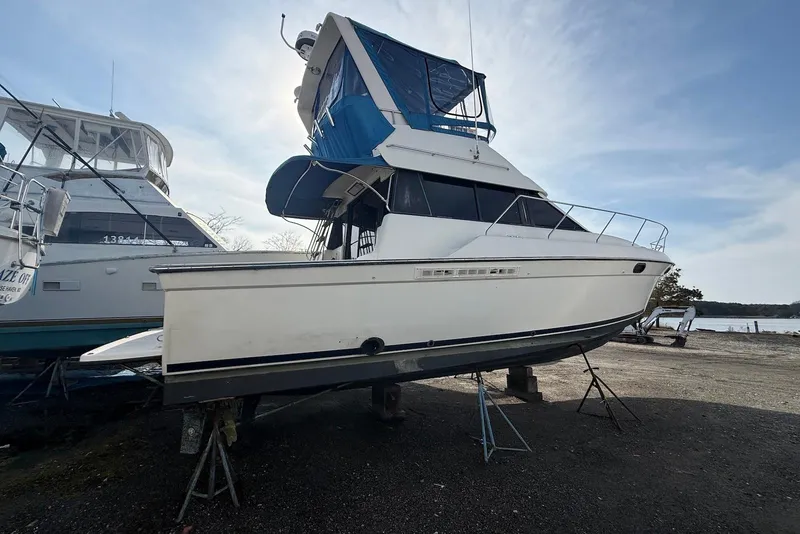 Slide: The Image of 1990 Silverton 37 Convertible boat on stands, side view, outdoors. - 15