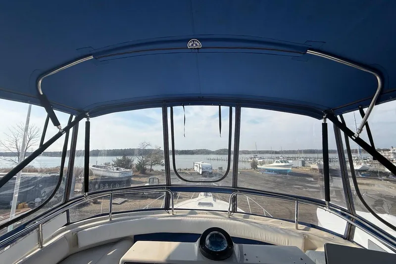 Slide: The Image of 1990 Silverton 37 Convertible boat interior with blue canopy, overlooking marina and water. - 17