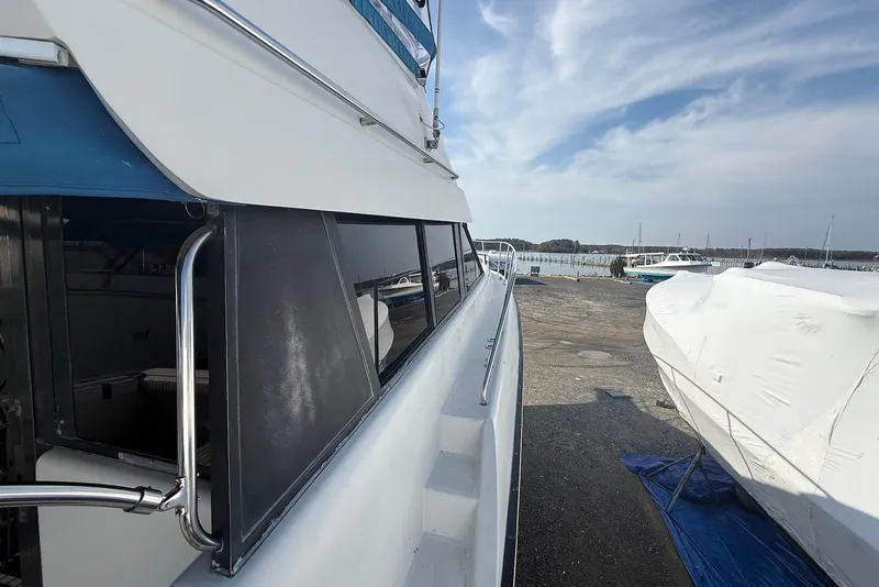 Slide: The Image of 1990 Silverton 37 Convertible yacht docked, side view with clear sky background. - 18