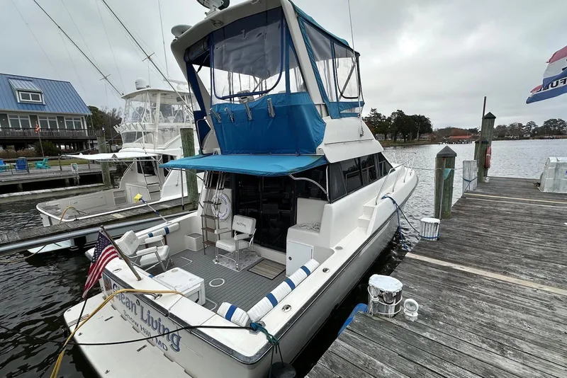 Slide: The Image of 1990 Silverton 37 Convertible yacht docked at marina with blue canopy. - 2