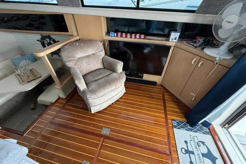 Slide: The Image of Interior of 1990 Silverton 37 Convertible with chair, TV, and wooden flooring. - 21