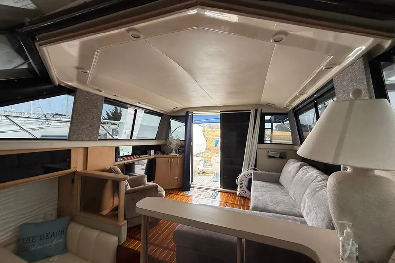 Slide: The Image of Interior of a 1990 Silverton 37 Convertible yacht with cozy seating and elegant decor. - 25