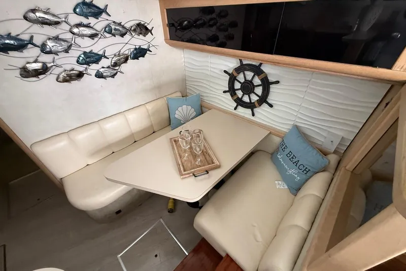 Slide: The Image of 1990 Silverton 37 Convertible interior with nautical decor and cozy seating area. - 26