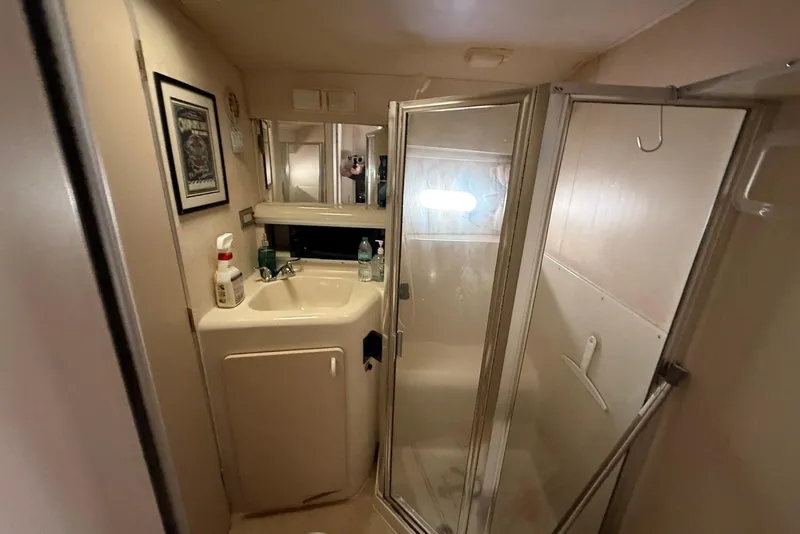 Slide: The Image of 1990 Silverton 37 Convertible bathroom with sink, mirror, and shower enclosure. - 27