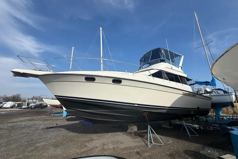 Slide: The Image of 1990 Silverton 37 Convertible boat on dry dock under clear blue sky. - 5
