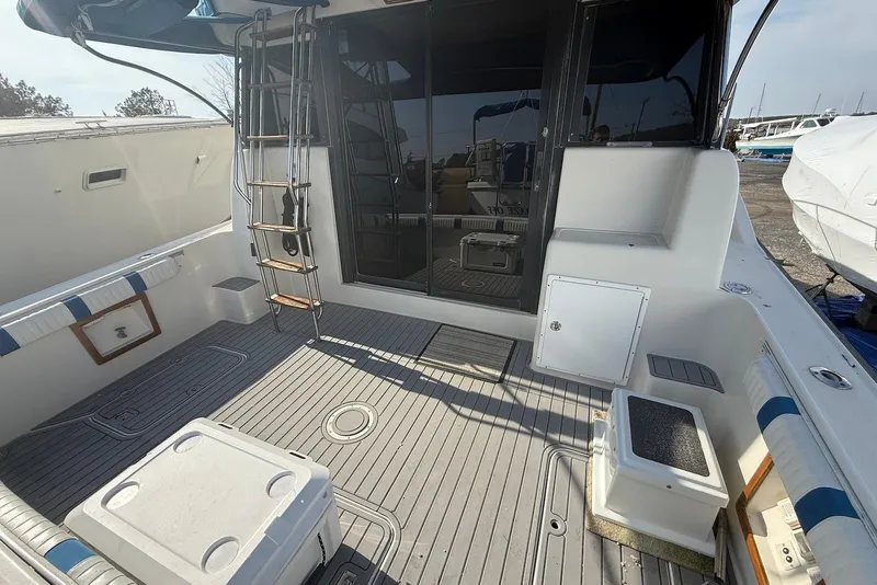 Slide: The Image of 1990 Silverton 37 Convertible boat deck with seating, ladder, and storage compartments. - 6