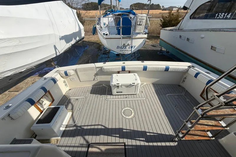 Slide: The Image of 1990 Silverton 37 Convertible boat deck with seating and storage, docked outdoors. - 7