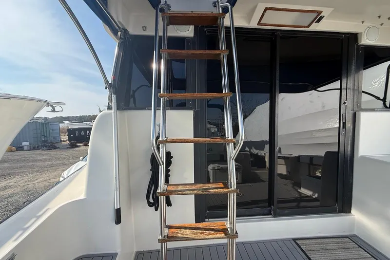 Slide: The Image of 1990 Silverton 37 Convertible yacht with wooden ladder and sliding glass doors. - 8