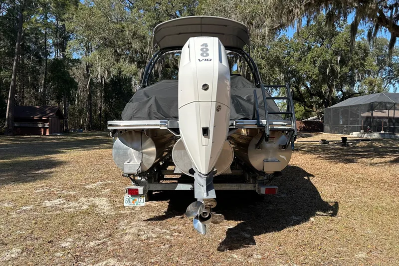 Slide: The Image of 2023 Bennington LX 26 Swingback boat with powerful outboard motor, parked outdoors. - 5