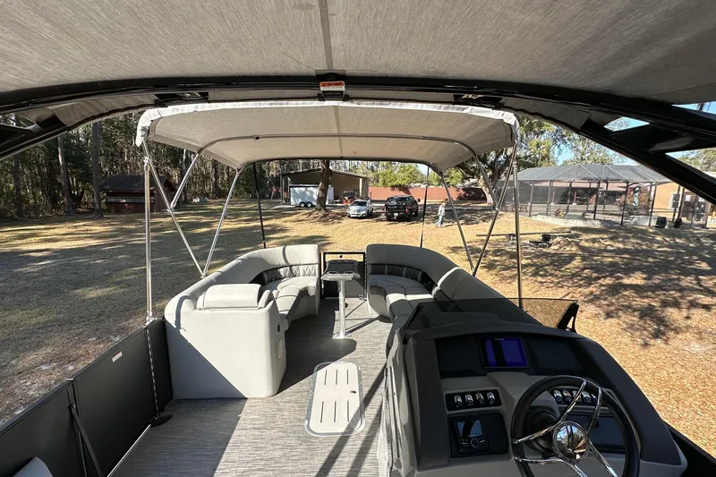 Slide: The Image of 2023 Bennington LX 26 Swingback pontoon boat interior with canopy and seating. - 7